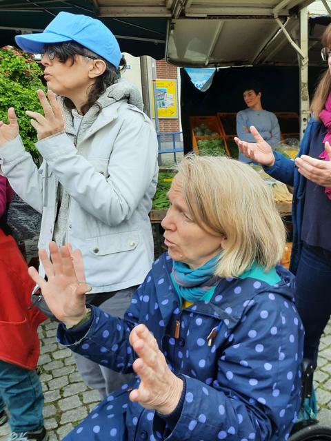 Auf dem Bild sind zwei Personen zu sehen, die am Aktionstag mit gemacht haben, als ein Lied in Deutscher Gebärdensprache präsentiert wurde.