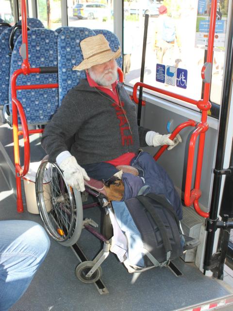 Auf dem Bild ist ein Mann zu sehen, der im Rollstuhl sitzt und sich in einem Bus auf einen Rollstuhlplatz gestellt hat.